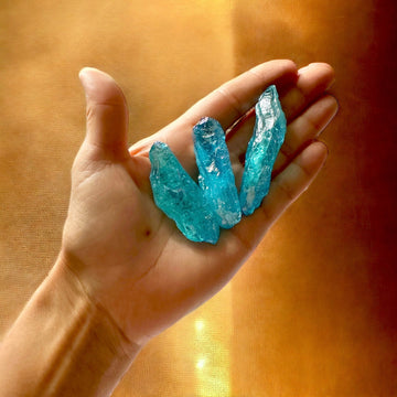 Ametystowy amulet Aqua Aura Sukcesu i Obfitości od Ewa Mrochen Jewellery, z błyszczącym kryształem i złotym wykończeniem.