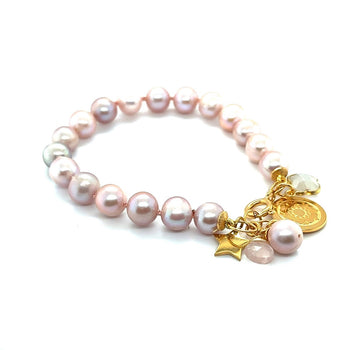 Różowa bransoletka Symfonia Miłości od Ewa Mrochen Jewellery z perłami i delikatnym designem na tle białej tkaniny