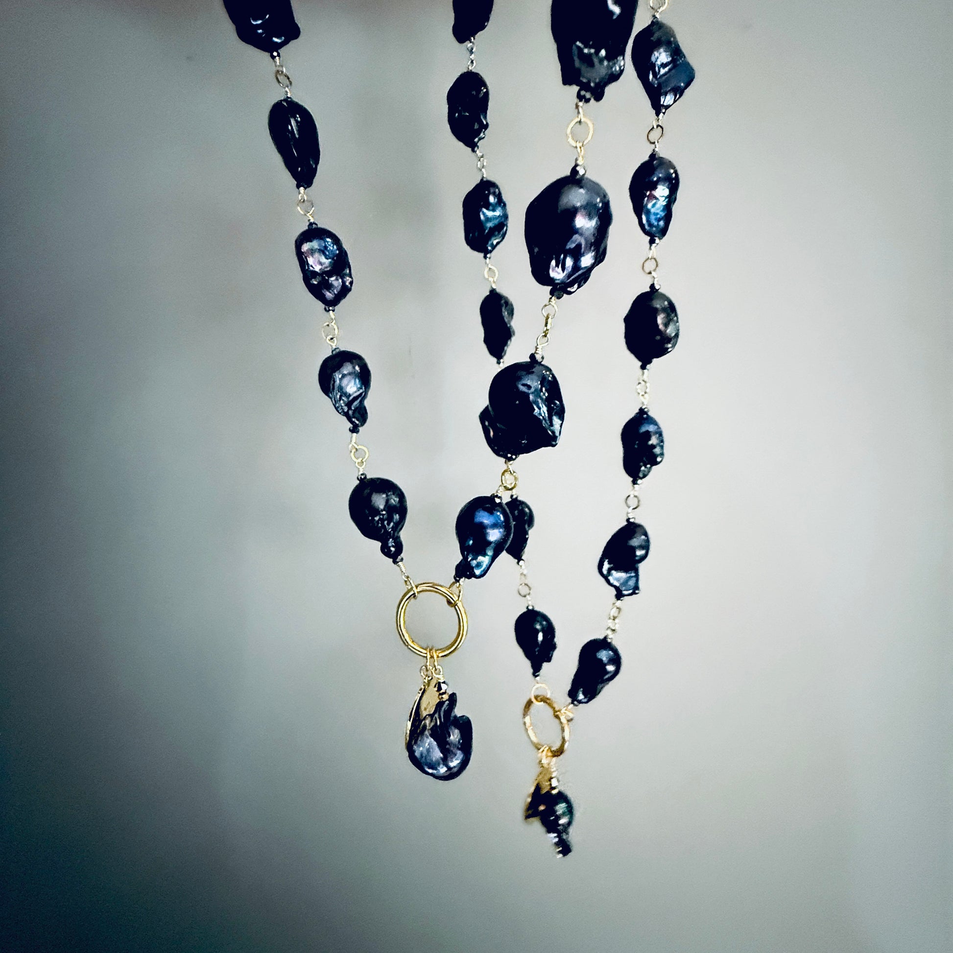 Czarny barokowy naszyjnik z perłą od Ewa Mrochen Jewellery, elegancki i ozdobny, na zdjęciu widoczny naszyjnik z czarną perłą.