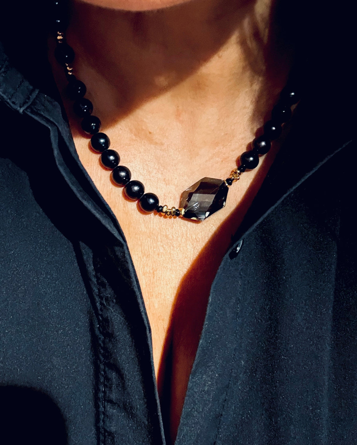 Czarny naszyjnik Black Beauty z perłą, marki Ewa Mrochen Jewellery®, na zdjęciu na tle neutralnym.