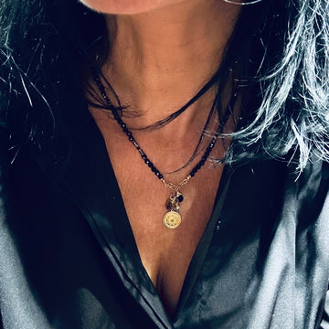Czarny turmalin naszyjnik Ewa Mrochen Jewellery® z kamieniem ochronnym i pozytywną energią, na tle ciemnego tła.