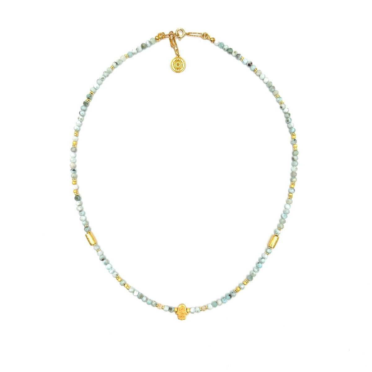 Larimar naszyjnik Boska Kobiecość od Ewa Mrochen Jewellery z niebieskim kamieniem i delikatnym łańcuszkiem na tle białej tkaniny