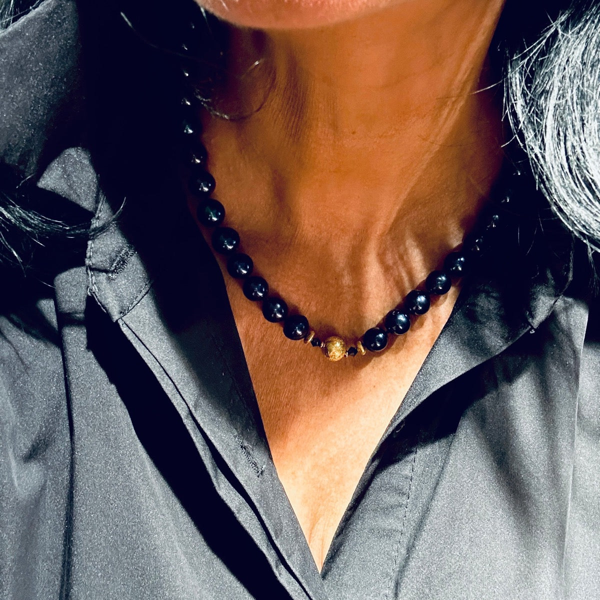 Naszyjnik z granatowych pereł marki Ewa Mrochen Jewellery, elegancki i ręcznie wykonany, na zdjęciu widoczny detal biżuterii.