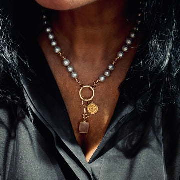 Srebrzysty naszyjnik z perłą od Ewa Mrochen Jewellery® otulony świetlistością, elegancki dodatek do eleganckiej stylizacji