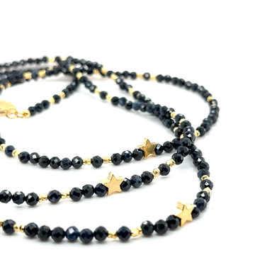 Złoty naszyjnik Ewa Mrochen Jewellery z dużym szafirem, luksusowy i elegancki, na tle czarnego tła, detalowana biżuteria.