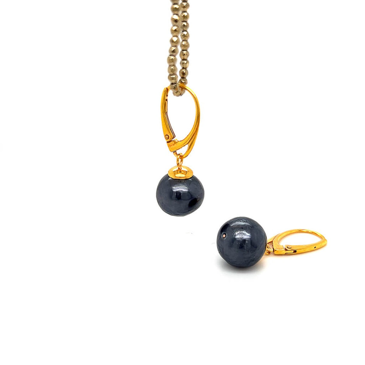 Kolczyki z perłą czar Ewa Mrochen Jewellery, angielskie kolczyki srebrne z elegancką perłą na tle czarnego kolczyka.
