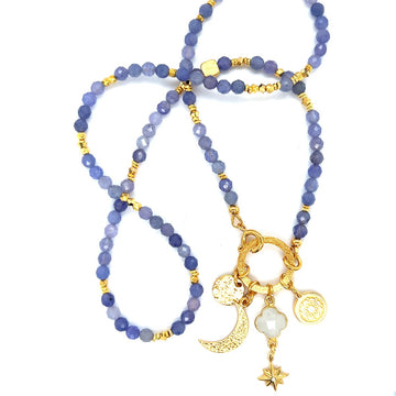 Naszyjnik z tanzanitu "Moc jest Kobietą" od Ewa Mrochen Jewellery na tle, ukazujący elegancki design i błyszczący kamień.