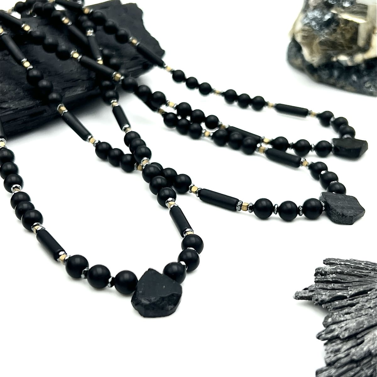 Czarny turmalin w naszyjniku Ewa Mrochen Jewellery, elegancki naszyjnik z kamieniem nieustraszoności, na czarnym tle.