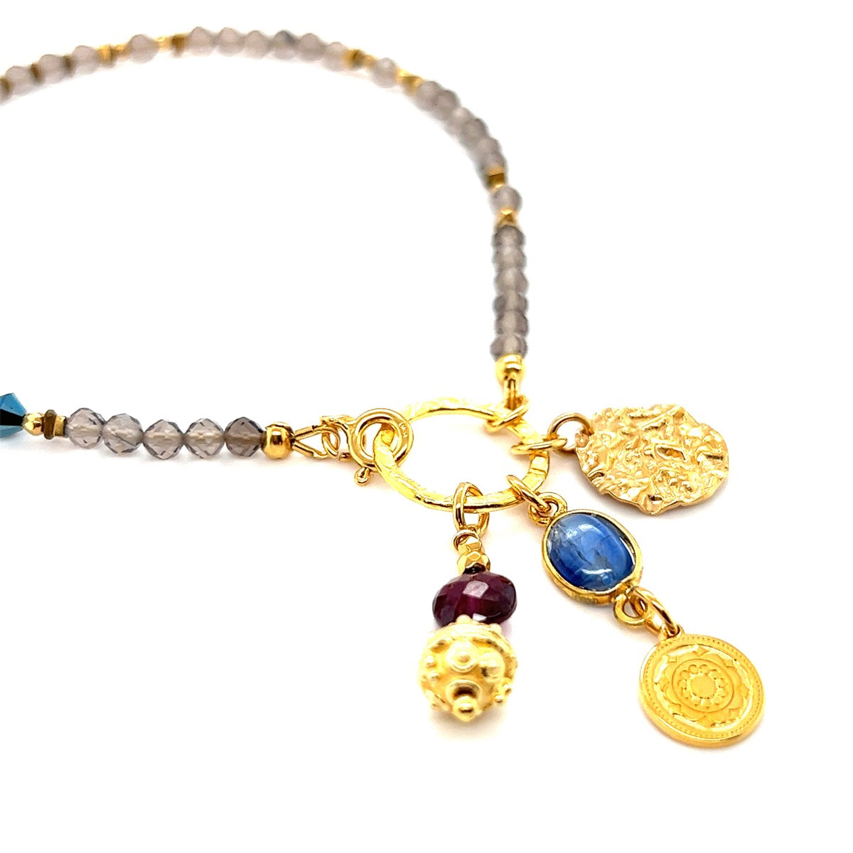 Naszyjnik z kwarcu dymnego, kyanitu i granatu od Ewa Mrochen Jewellery, zawieszony na delikatnym łańcuszku.