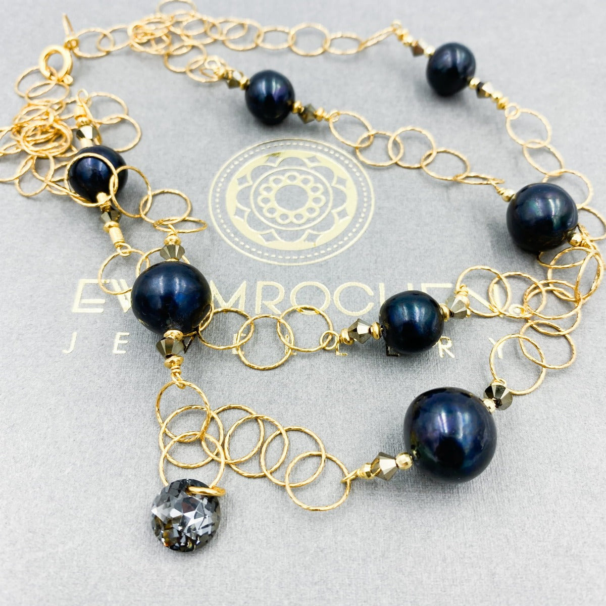 Naszyjnik z czarną perłą od Ewa Mrochen Jewellery, elegancki dodatek z unikalnym designem i subtelnie połyskującą perłą.