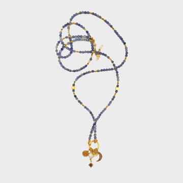 Długi naszyjnik z tanzanitami od Ewa Mrochen Jewellery, ozdobiony kamieniami i eleganckim designem, na tle neutralnym.