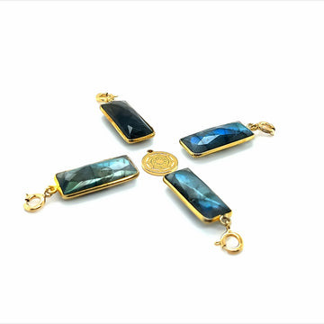 Zawieszka z labradorytem Wytworna od Ewa Mrochen Jewellery na tle czarnego tła, detal i naturalny błysk kamienia.